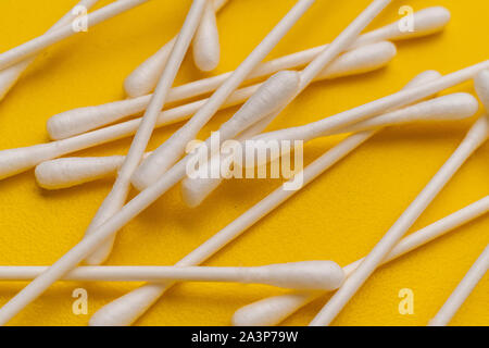 Bündel von Baumwolle Ohr sticks Putzlappen auf gelbe Oberfläche, Makro Ansichten Stockfoto