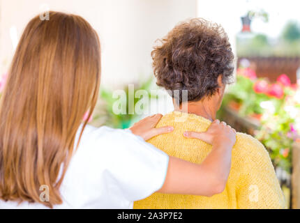 Foto von pflegeperson Massage die ältere Frau Schulter Stockfoto