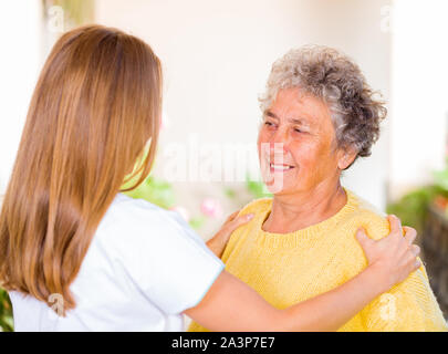 Foto von pflegeperson Massage die ältere Frau Schulter Stockfoto