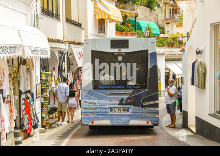 POSITANO, ITALIEN - AUGUST 2019: Bus voller Menschen die Aushandlung einer der engen Straßen in der Stadt Positano in Italien Amalfi Küste Stockfoto