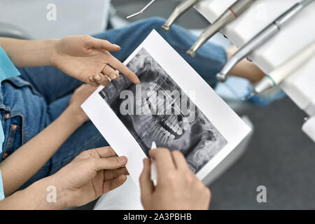 Die hübsche Frau, die Zähne Behandlung in der Zahnarztpraxis Stockfoto