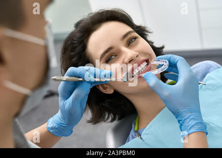 Die hübsche Frau, die Zähne Behandlung in der Zahnarztpraxis Stockfoto