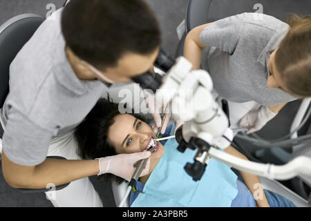 Die hübsche Frau, die Zähne Behandlung in der Zahnarztpraxis Stockfoto