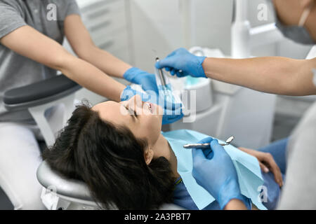 Die hübsche Frau, die Zähne Behandlung in der Zahnarztpraxis Stockfoto