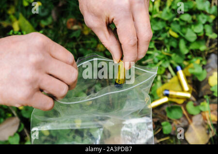 Die Hand des Mannes setzt die verwendeten Batterien in die Tasche. Stockfoto