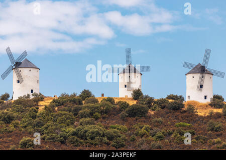 Horizontale Ansicht von drei alten Windmühlen in der Landschaft der spanischen Gemeinde Villanueva de los Infantes an einem Sommertag mit blauen bewölkten Himmel Stockfoto