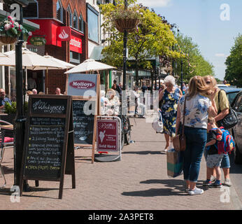 Die Menschen genießen einen Spaziergang vorbei an Geschäften reden und sie saßen auf einem sonnigen Sommertag in Lytham Lancashire England Großbritannien Stockfoto