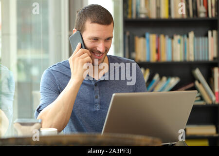 Glückliche Menschen Gespräche am Telefon prüfen laptop Inhalte in einer Bar oder nach Hause sitzen Stockfoto