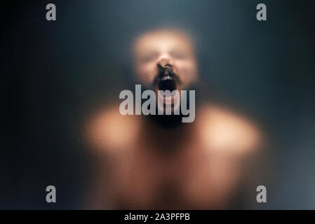 Creepy Mann hinter dem milchglas Schreien. Stockfoto