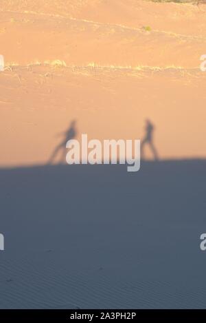 Zwei Forscher auf der Wüste, Casting Shadows auf den Sanddünen an einem heißen, sonnigen Tag. Stockfoto