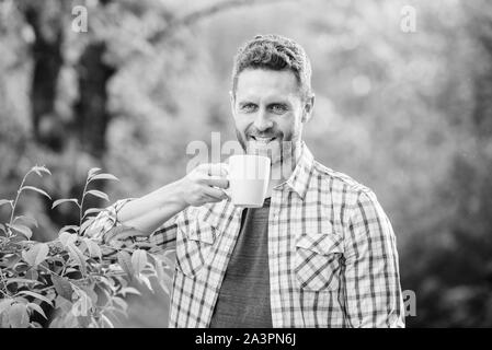 Grüner Tee Plantage. Vollständige blatt Tee. Hervorragender Geschmack. Genießen Sie heiße Getränke. Natürliche trinken. Gesunde Lebensweise. Ich bevorzuge grünen Tee. Erfrischendes Getränk. Man bärtige Kaffee Bauer halten Becher Natur Hintergrund. Stockfoto