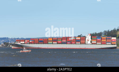 San Francisco, CA - 18. Februar 2019: Frachtschiff HANNOVER BRÜCKE Abfahrt im Hafen von Oakland, das Fünfte betriebsamsten Hafen in den Vereinigten Staaten. Stockfoto