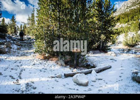 Frau wandern auf dem schneebedeckten Weg entlang Little Lakes Valley in den östlichen Sierra Nevada Mountains. Kalifornien, USA Stockfoto