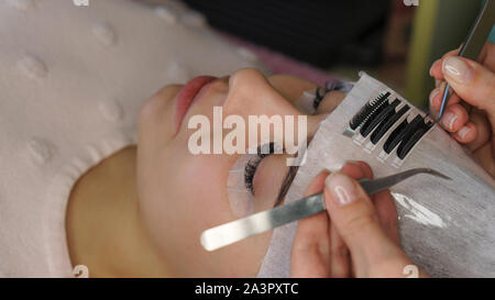 Schöne Frau mit langen Wimpern in einem Schönheitssalon. Eyelash Extension verfahren. Stockfoto