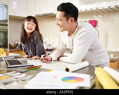 Junge asiatische Designer Vater zu Hause arbeiten, während die Pflege der Tochter. Stockfoto