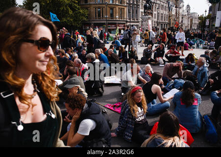 Mitglieder des Klimawandels in der Aktivistenbewegung, Aussterben Rebellion (XR) Sitz in Trafalgar Square am dritten Tag von der Gruppe "Internationale Rebellion' in London. Polizisten weiterhin klare Demonstranten und Zelten von Standorten in Westminster, mit Aktivistinnen in zum Verschieben in einen speziellen Protest Bereich um Nelson's Column auf den Trafalgar Square oder Gesicht Verhaftung gewarnt worden. Ähnliche Blockaden vom Aussterben Rebellion im April, an Standorten mit der Oxford Circus und Waterloo Bridge, sah mehr als 1.000 verhaftet, eine Taktik, gefördert von XR Gründer Roger Hallam als Mittel der Maximierung der di Stockfoto