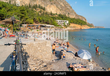 Nafplio Griechenland - 19 Juli 2019; Badegäste am Strand Arvanitia in Griechenland enjoyng im Sommer dat Sonnenbaden und Schwimmen. Stockfoto