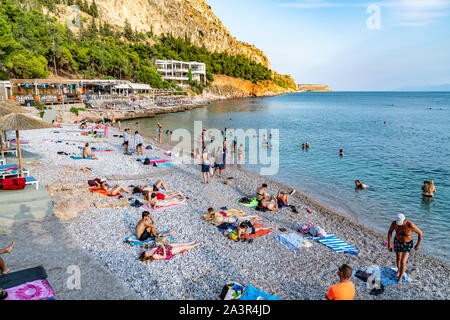 Nafplio Griechenland - 19 Juli 2019; Badegäste am Strand Arvanitia in Griechenland enjoyng im Sommer dat Sonnenbaden und Schwimmen. Stockfoto