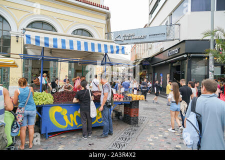 Athen Griechenland - 15. Juli 2019; Touristen vorbei und Kauf von Obst aus Straße Obst Anbieter unter Flohmarkt Athens anmelden Plaka. Stockfoto