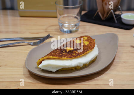 Cachapa mit Käse, typisch venezolanischen Gericht mit Mais, Käse und Butter auf Stein Teller gemacht Stockfoto