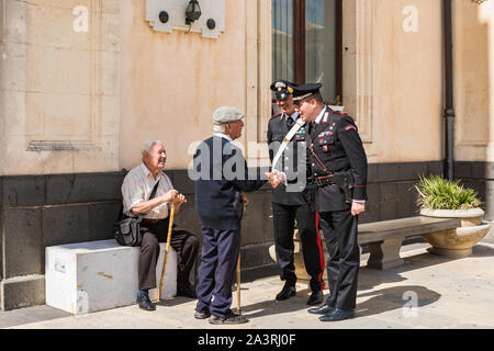 Syrakus Sizilien/Italien - 04 Oktober 2019: Carabinieri mit zwei ältere Menschen in der Stadt diskutieren Stockfoto