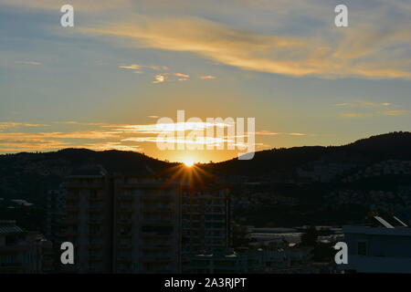 SUNRISE Mahmutlar, Alanya Türkei. Die Sonne über dem Kargicak Hügel und mahmutlar Dächer und Leuchtet der Himmel als der neue Tag beginnt. Stockfoto