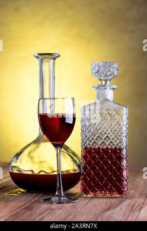 Dekanter mit Rotwein und Glas auf Stuck Hintergrund mit Freistellungspfaden. Stockfoto