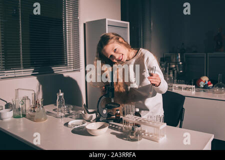 Mädchen Schülerin stehen in der Nähe des Tisches in der Chemie Zimmer Stockfoto
