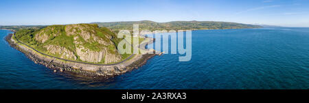 Nordirland, Großbritannien. Breite Antenne Panorama der Ballygalley Head Mountain und Causeway Coastal Route alias Antrim Coast Road in der Nähe von Larne Stockfoto