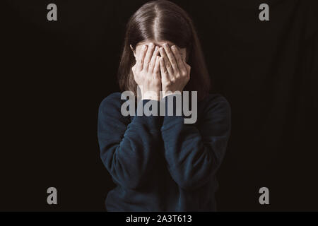 Gewalt. Weinende Frau auf schwarzem Hintergrund. Stockfoto