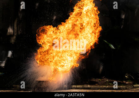 Flammen, die durch die Explosion der Öl verursacht. Demonstration Wasser auf das Feuer. Stockfoto