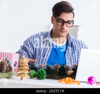 Der junge Mann, der weihnachtsdekoration von Kegel Stockfoto