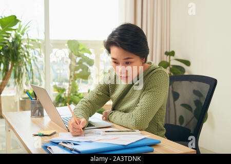 Jungen asiatischen Geschäftsfrau, die sich auf Ihre Dokumente Stockfoto