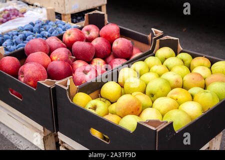 Kisten mit Äpfeln auf einem Bauernmarkt. Kartons mit verschiedenen Arten von Äpfeln in der lokalen landwirtschaftlichen Markt. Frische Äpfel direkt vom Baum sind auf dem freien Markt verkauft. Stockfoto