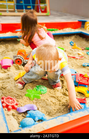 Kleine Kinder spielen mit Sand am Spielplatz. Stockfoto