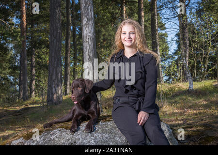 Junge Frau im Freien mit einem schönen jungen Labrador Retriever Welpen Stockfoto