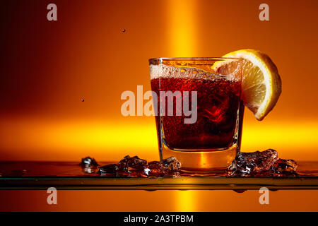 Glas Cola mit Zitrone in Scheiben schneiden. Cocktail mit Zitrone. Kopieren Sie Platz. Stockfoto