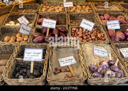 Verschiedene Arten von roten Zwiebeln, Knoblauch und Kartoffeln in Weidenkörbe, an Street Food Markt. Stockfoto