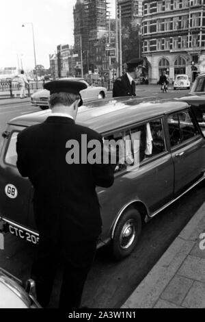 In das Sterben Stadtkasse voll werde: ein Falschparker Strafzettel Polizeibeamte wound in Amsterdam, Niederlande 1971. Stadt treasury ausgefüllt werden: Polizisten Entsorgung Parkplätze Verletzung Tickets in Amsterdam, Niederlande, 1971. Stockfoto