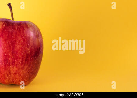 Halber roter Apfel auf gelben Hintergrund, frisches Obst, saftige Frucht, Makro apple Stockfoto