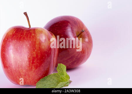 Rote Äpfel auf weißem Hintergrund, Minze, Gruppe von zwei Stockfoto