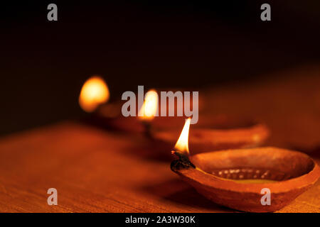 Foto von Diwali diya oder Ton öl Lampe leuchtet während des Festival der Lichter in Indien. Dunkle moody Hintergrundbild diyas für Diwali Grußkarte. Stockfoto