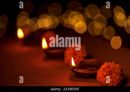 Diwali Dekoration mit traditionellen diya Öllampen, Ringelblume Blumen und goldenen Bokeh während Diwali festliche Feier der Nacht. Stockfoto