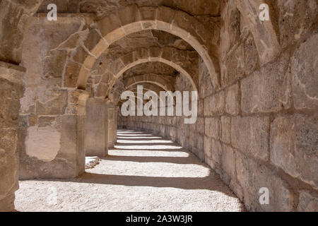 Schöne Perspektive eines der gewölbten Gängen des Römischen Amphitheater, Aspendos, eine touristische Attraktion in Antalya, Türkei. Schöne Stein text Stockfoto