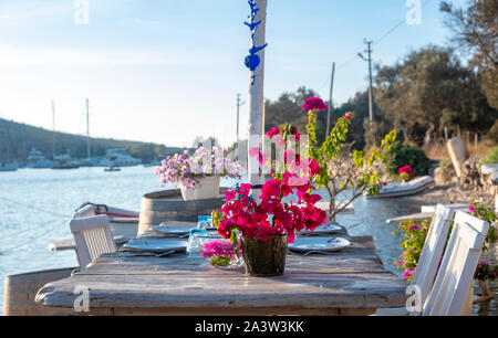 Seaside Holztisch und Stühlen öffnen Cafe Restaurant im Freien in Gumusluk, Bodrum - Türkei am Meer. Sommer Urlaub im Resort. Stockfoto