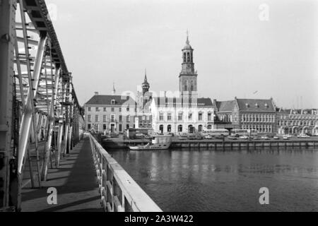 Blick von der Brücke auf den Rathausturm Stadsbrug und De Nieuwe Riss in Kampen, Niederlande 1971. Blick von Stadsbrug Brücke zum Rathaus und der neue Turm de nieuwe Toren" in Kampen, Niederlande, 1971. Stockfoto