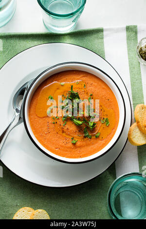 Cremesuppe von roten Linsen mit Tomaten auf dem Tisch. gesund vegan Erwärmung Essen für die ganze Familie. Stockfoto