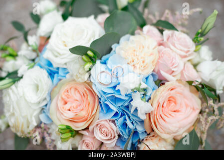 Close-up Braut diamantene Hochzeit Band und Engagement Ring in Bräute floralen Bouquet platziert Stockfoto