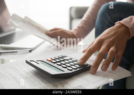 Frau mit Taschenrechner holding Rechnungen Planung Aufwendungen, Ansicht schließen Stockfoto