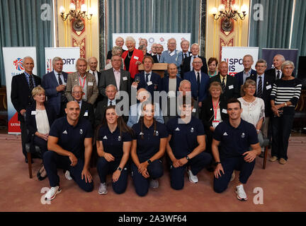 Die 1964 Olympioniken mit dem neuen Team GB Olympioniken (vordere Reihe: von links nach rechts) Liam Heide, Kimberley Woods, Mallory Franklin, Adam Burgess und Bradley Forbes-Cryans feiern den 55. Jahrestag der Eröffnung der Olympischen Spiele 1964 in Tokio im Ministerium für auswärtige Angelegenheiten und Commonwealth-Fragen, London. Stockfoto